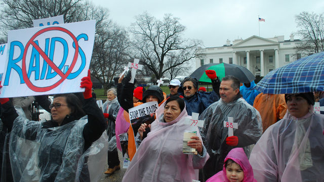 People rally outside of the White House in opposition to immigration raids.