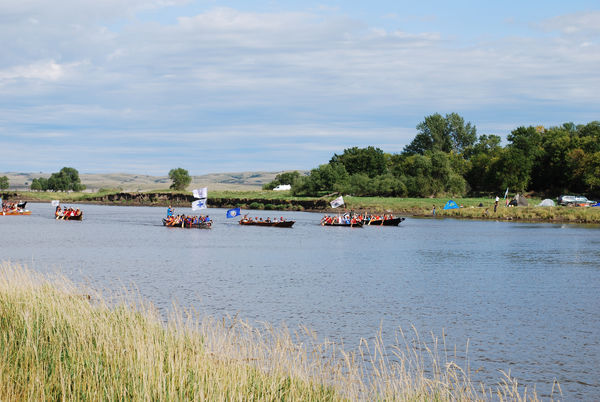 Native Americans travel to the Standing Rock camp by canoe