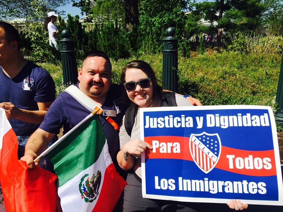 GBCS Staff Amber Feezor poses with another attendee at an immigration rally. She holds a sign that reads, "justicia y dignidad para todos los immigrantes"