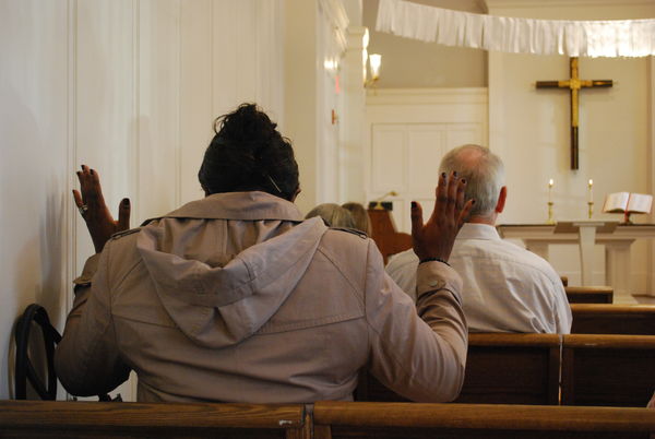 Woman holds hands up in prayer