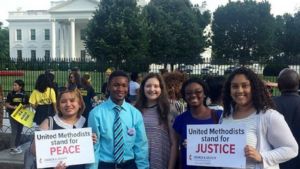 Interns stand in front of White House holding sings that read "United Methodist Stand For Justice," and "United Methodist Stand for Peace."