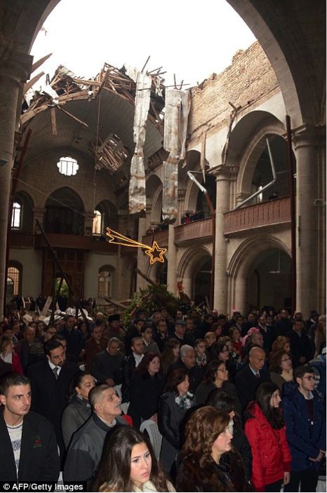Christians worship in a church after a bombing has ruined the roof. 
