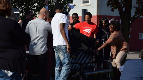 A diverse group in Adrian, Mich., unveils their "Bench by the Road."