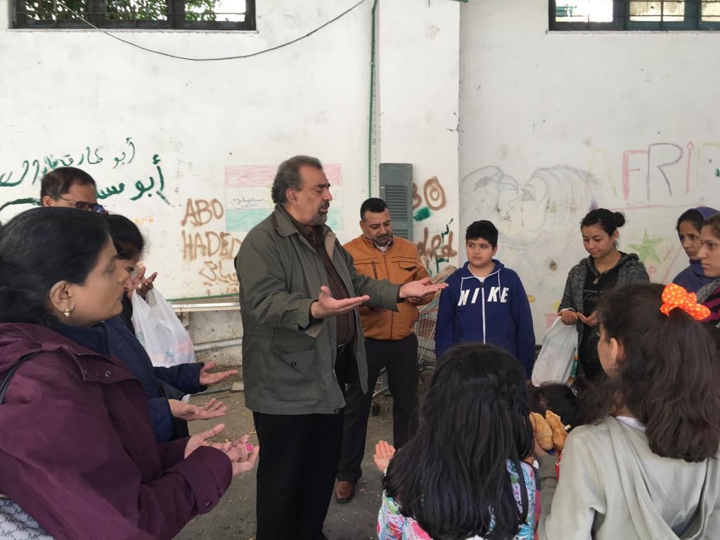 Reverend Doctor Zaki Labib Zaki leads a prayer for a group of refugees during a mission trip in Athens, Greece with the Middle Eastern United Methodist Caucus. 