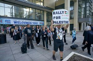 A photo of protesters, one holding up a sign that says "Rally for Palestine"