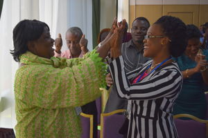 Two women high five in crowd.