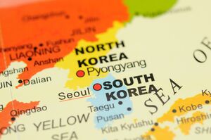 A watercolor painting of the Korean Peninsula, with north Korea painted red and south Korea painted blue.