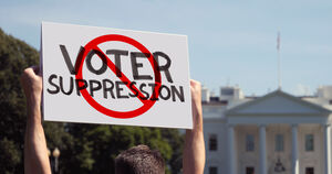 A protester holding up a sign that reads "Voter Suppression" with cross out sign over it.