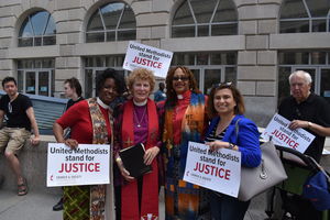 rally with United Methodists holding United Methodists stand for justice signs