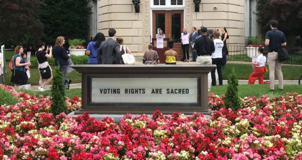 sign that says Voting is a sacred act