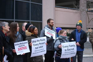 Advocates hold signs reading "United Methodists Stand for Justice"