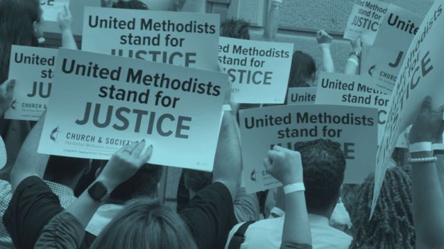A group of people holding signs saying "United Methodists stand for Justice."