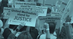 A group of people holding signs saying "United Methodists stand for Justice."