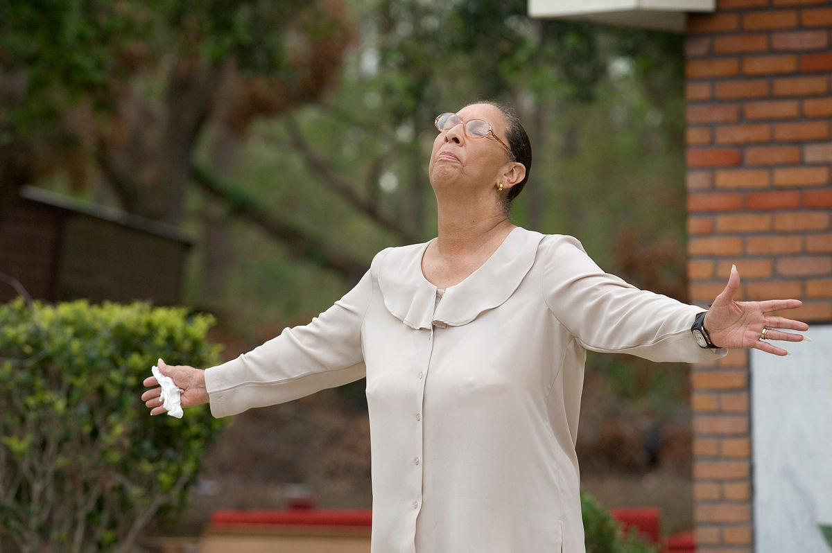 Ella Doyle lifts her head in prayer and tells fellow parishioners to “hold your head up” during an outdoor worship service at Hartzell Mt. Zion United Methodist Church in Slidell, La., shortly after Hurricane Katrina in September 2005. The church’s sanctuary was ruined by the storm surge. Doyle said she rode out the storm in a boat with her husband and two sons. File Photo by Mike DuBose, UM News.