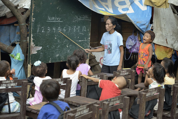 Indigenous children displaced by paramilitary violence attend school in a makeshift classroom in a church compound in Davao in 2016, on the southern Philippine island of Mindanao. Hundreds of Indigenous were living in the church center, afraid to return home.