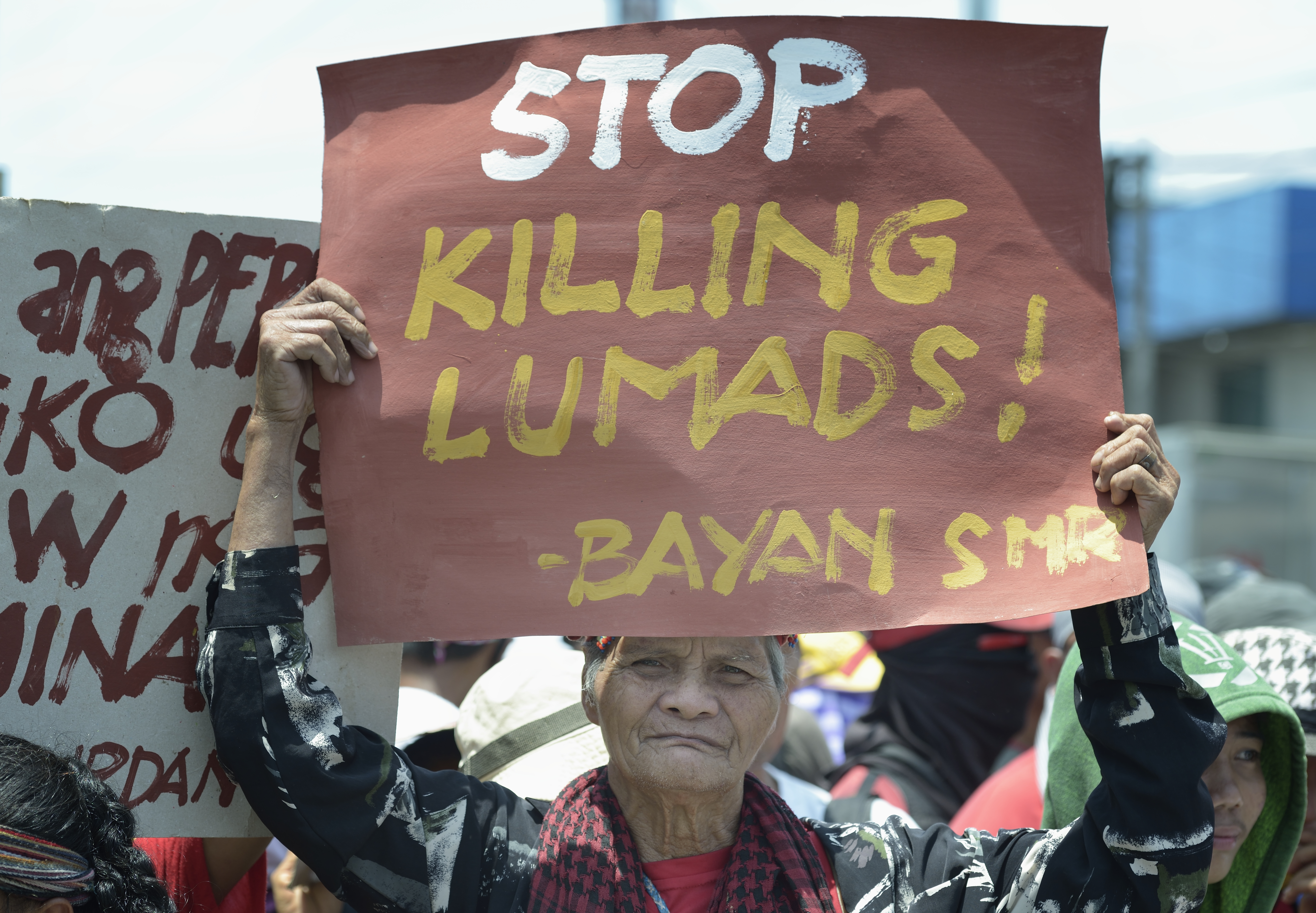 An Indigenous man holds a sign during a demonstration in 2016 outside a military base in Davao, on the southern Philippine island of Mindanao. Hundreds of Indigenous (known locally as Lumads) were living in a church compound in the city, chased out of their rural villages by paramilitary squads. Photo © Paul Jeffrey, Life on Earth Pictures