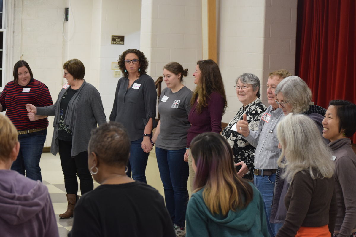 Large group holds hands in a circle. 