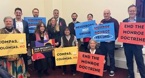 People holding signs that say "End the Monroe Doctrine" 
