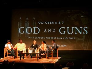 Panel of speakers in front of backdrop that says "God and Guns"